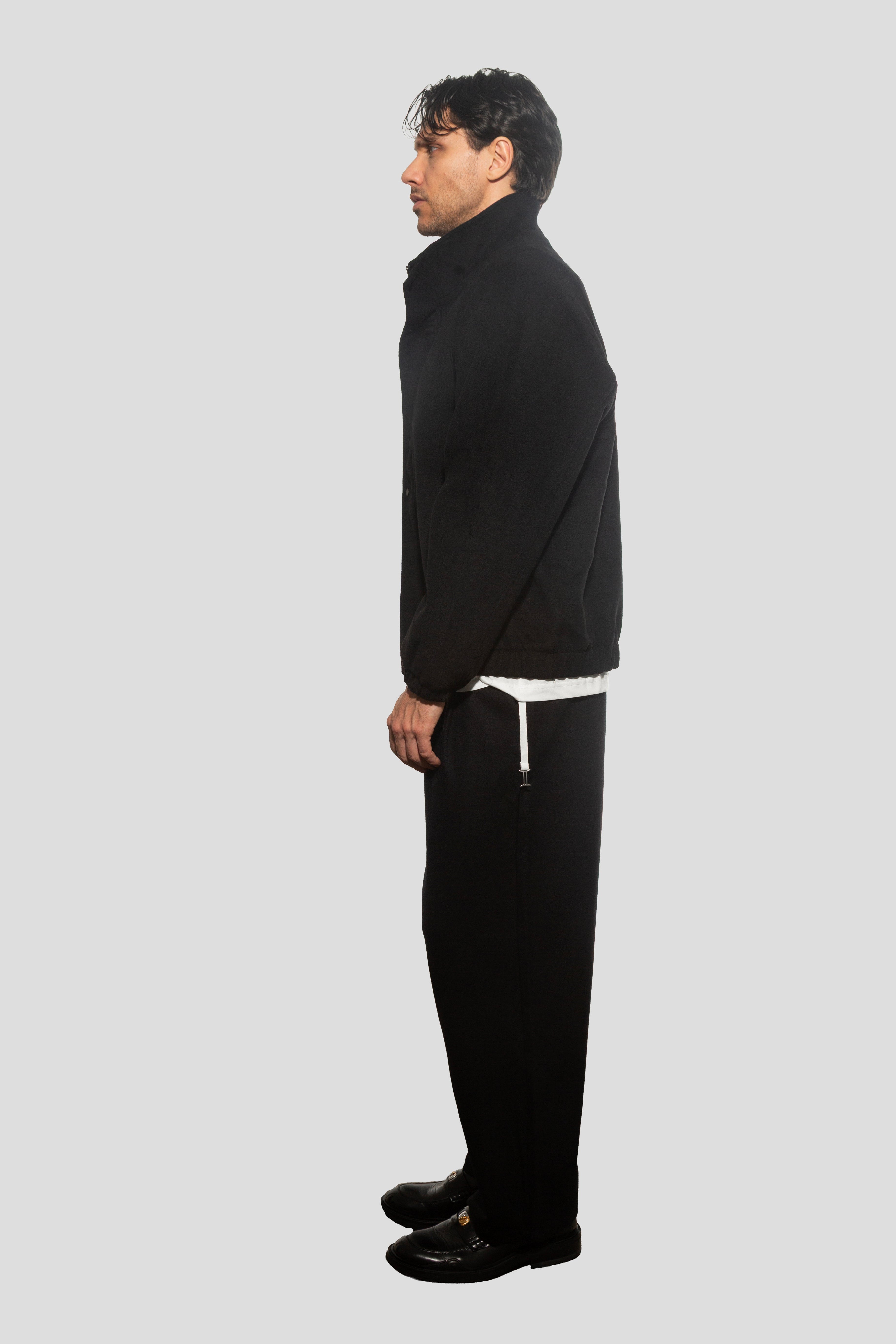 Man wearing a black outfit on a white background
