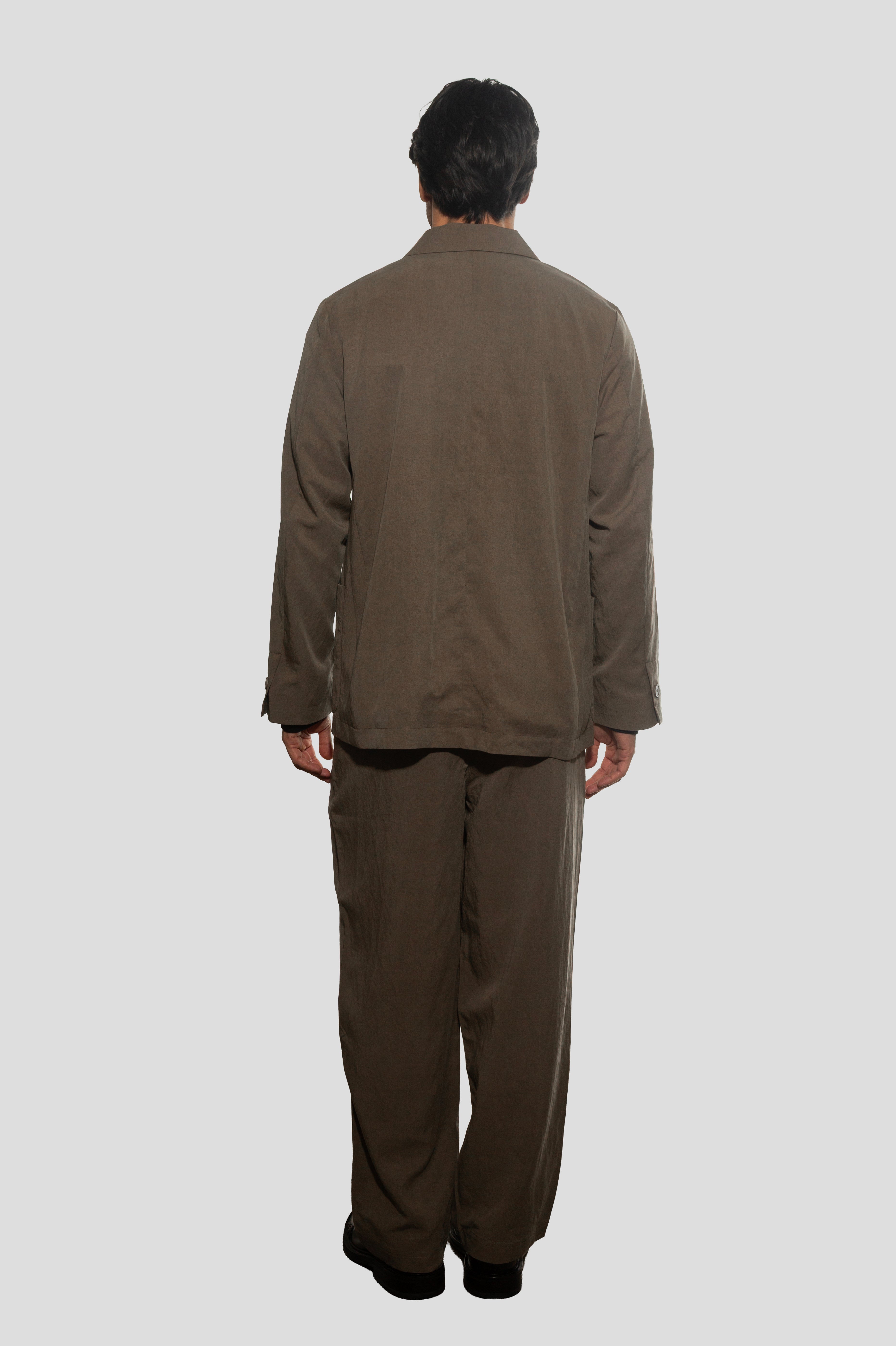 Person wearing a brown suit on a white background